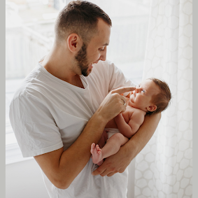 pai ninando seu bebê e brincando com ele