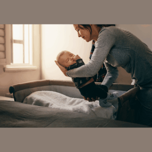 Mãe embalando bebé sonolento durante a rotina noturna calma.